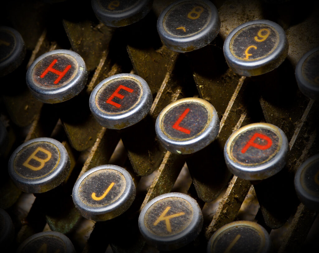H E L P spelled out on typewriter keys